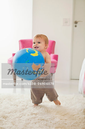 Baby boy playing with a globe ball