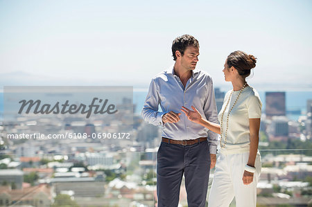 Couple discussing on a terrace with city in the background