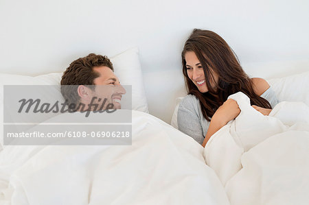 Smiling couple lying on the bed