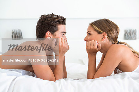 Couple lying face to face on the bed