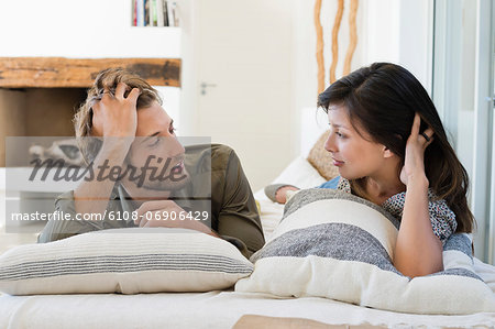 Couple lying on the bed and looking at each other
