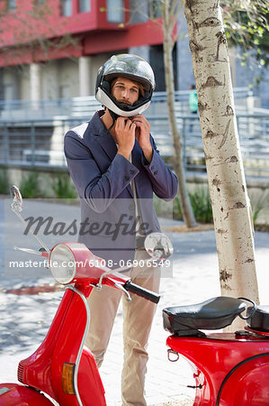 Man standing near a scooter on a street