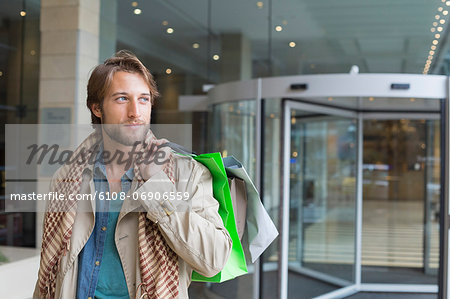 Man carrying shopping bags on his shoulders