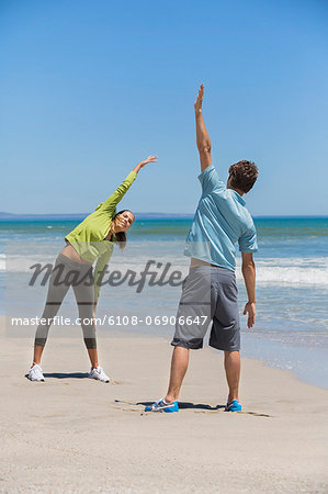 Woman and her coach exercising on the beach