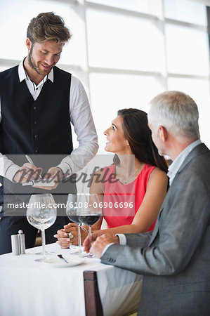 Waiter taking orders from a couple in a restaurant