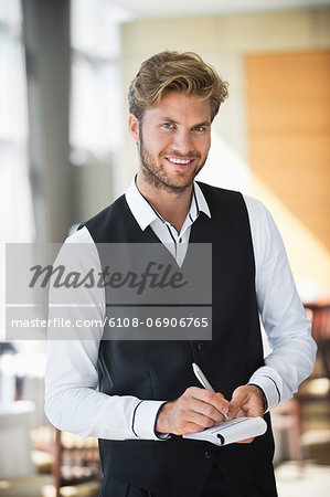 Portrait of a waiter taking order in a restaurant