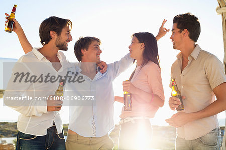 Four friends enjoying beer in party