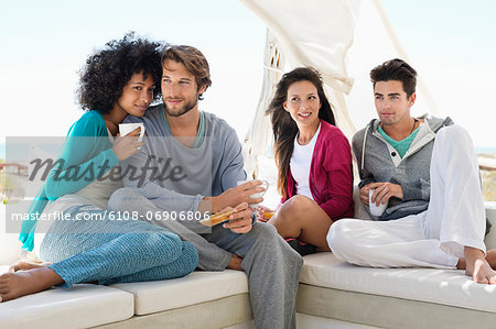 Smiling friends enjoying coffee on the terrace