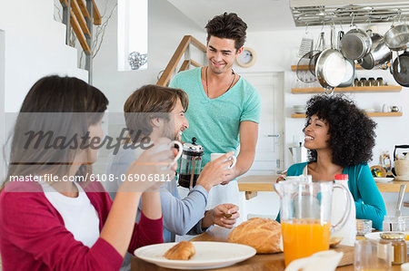 Friends sitting at a dining table having breakfast