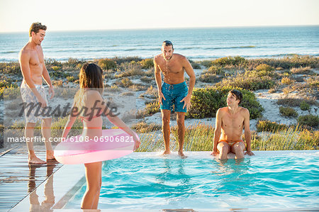 Group of friends enjoying in a swimming pool on the beach