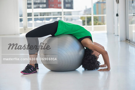 Woman exercising on a fitness ball in a gym