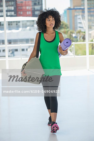 Woman carrying an exercise mat and a bag