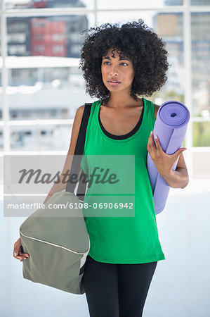 Woman carrying an exercise mat and a bag