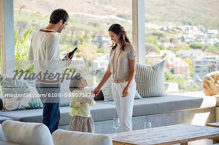 Couple standing in a living room with their daughter