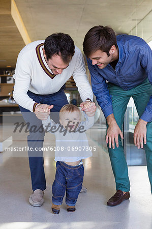 Parents helping their son to walk