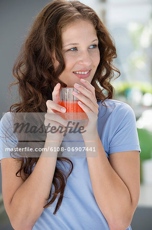 Smiling woman holding a glass of orange juice