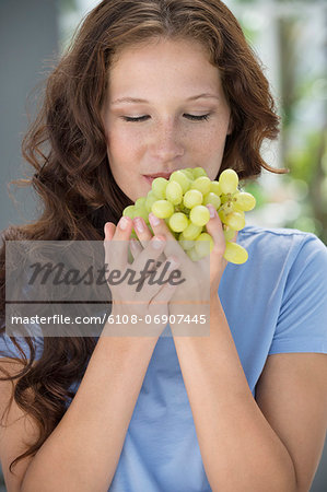 Close-up of a woman smelling grapes