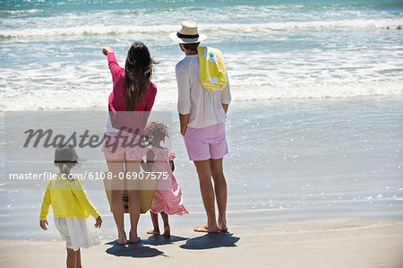 Children with their parents looking at sea on the beach