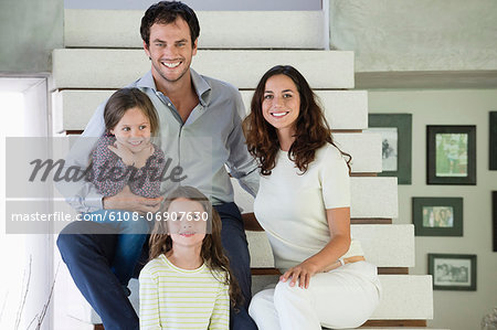 Family sitting on steps and smiling