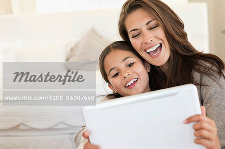 Woman and her daughter looking at a digital tablet