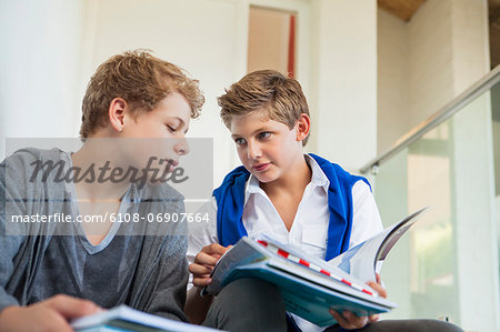 Two teenage boys studying in a school