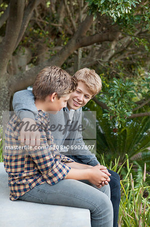 Two teenage boys sitting together and discussing