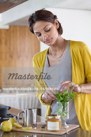 Woman preparing herbal tea in the kitchen