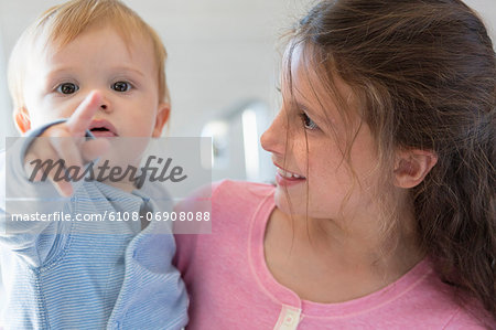 Girl with her brother smiling at home Girl with her brother smiling at home