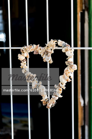 Heart shape made from sea shells hanging on a window