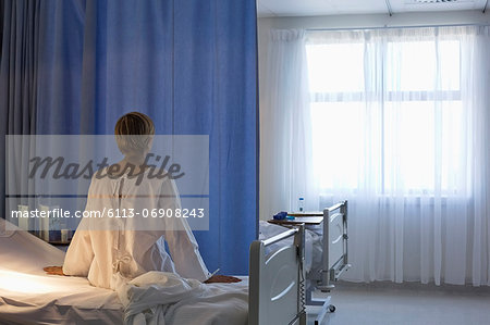 Patient wearing gown on hospital bed Patient wearing gown on hospital bed
