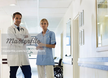 Doctor and nurse standing in hospital hallway