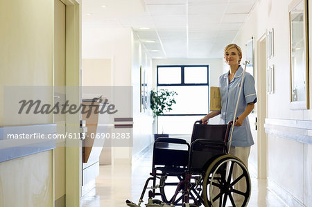 Nurse pushing wheelchair in hospital hallway