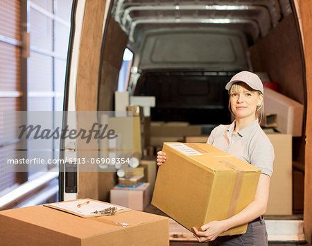 Delivery girl unloading boxes from van