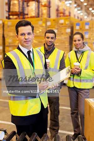 Businessman and workers in warehouse Businessman and workers in warehouse