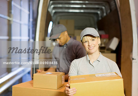 Delivery people loading boxes into van