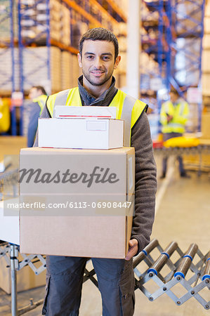 Worker carrying boxes in warehouse