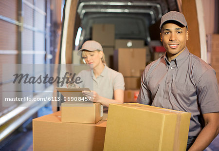 Delivery people loading boxes into van