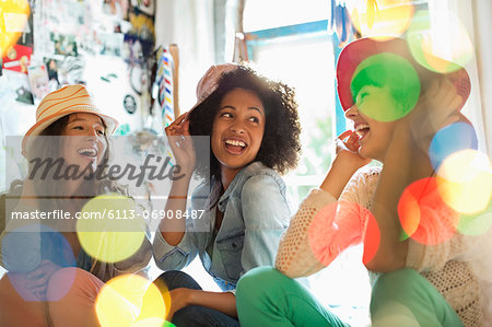 Women wearing hats in bedroom Women wearing hats in bedroom