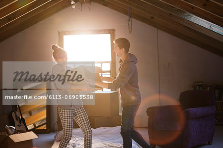 Couple unpacking box in attic