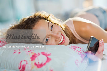 Woman using cell phone in bed