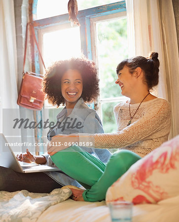 Women relaxing together in bedroom