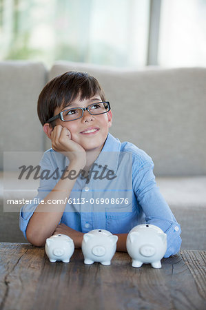 Boy sitting with piggy banks at coffee table