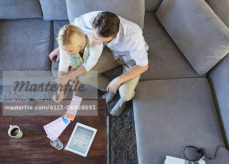 Couple using tablet computer on sofa