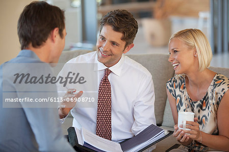 Financial advisor talking to couple on sofa