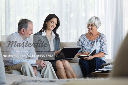 Financial advisor talking to couple on sofa Financial advisor talking to couple on sofa