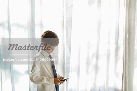 Boy in shirt and tie using cell phone