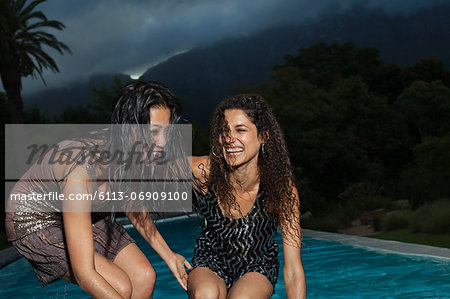 Women playing by swimming pool