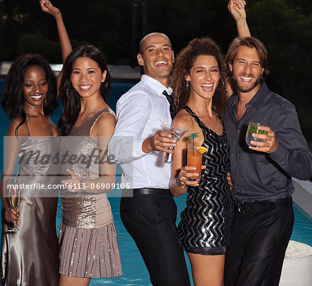 Friends dancing at party by swimming pool