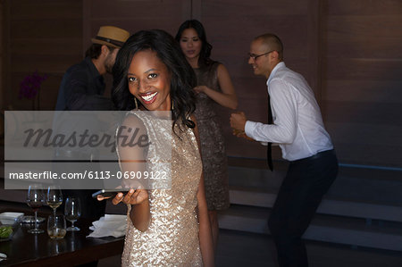 Woman using cell phone at party