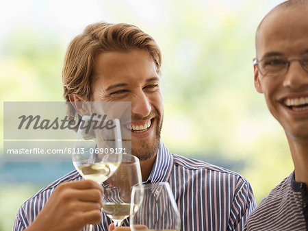 Men drinking wine together indoors